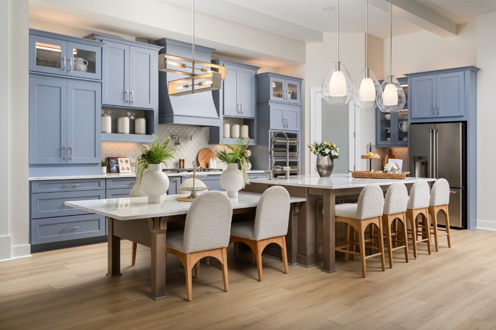 Modern Homes by WestBay kitchen with blue cabinetry, marble island, and dining seating